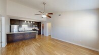 Located at 2716 Dawson Rd. in Albany, Georgia, this single-story, 2-bedroom, 2-bathroom residence offers a thoughtfully designed open-concept layout that maximizes functionality and comfort. The combined kitchen and living area serves as the heart of the home, featuring soaring vaulted ceilings, a ceiling fan with light fixture, and warm wood-look flooring throughout. Natural light flows in through large windows and a front entry door with glass panels, creating a bright and welcoming atmosphere.

The kitchen is well-equipped with rich dark-wood cabinetry, granite-look countertops, stainless steel appliances including a refrigerator, microwave, and gas range, a double-basin sink, and a dishwasher. Pendant lighting accents the space with a polished, modern touch.

Both bedrooms are carpeted and include ceiling fans, offering a comfortable retreat. The spacious primary bedroom provides ample room to accommodate a full furniture arrangement. The bathrooms feature tile flooring, vanities with granite-look countertops, and a tub/shower combination. A dedicated laundry area with built-in shelving adds everyday convenience. The hallway connects all areas of the home efficiently, completing this well-organized and move-in-ready residence.