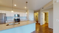 Located at 4001 De Morada Dr in Odessa, TX, this single-floor residence offers a well-designed, open-concept layout that seamlessly connects the kitchen and living areas. The kitchen is a standout feature, equipped with stainless steel appliances including a range, built-in microwave, and refrigerator. Crisp white shaker-style cabinetry pairs elegantly with a subway tile backsplash, while the expansive granite-topped island provides generous counter space, an undermount sink, and pendant lighting overhead — making it both functional and visually appealing. Recessed lighting throughout the kitchen adds to the bright, welcoming ambiance. Rich hardwood-style flooring flows through the main living and kitchen areas, complementing the neutral wall tones. The living area benefits from natural light through a glass door and windows, with a ceiling fan adding comfort. Bedroom spaces feature plush carpet flooring and clean, neutral walls, providing a calm and restful environment. One bedroom is finished with hardwood-style flooring for added versatility. The bathroom includes a tiled tub-shower combination, granite vanity countertop, and hardwood-style flooring, completing this thoughtfully appointed home.