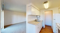 This 1-bedroom, 1-bathroom residence offers a thoughtfully designed single-floor layout that maximizes everyday functionality and comfort. The galley-style kitchen features white cabinetry with generous upper and lower storage, light countertops, a stainless steel sink, and white appliances including an electric range and refrigerator, all set over warm hardwood-style flooring. The kitchen flows seamlessly into a combined living and dining area, where soft carpet underfoot and bright white walls create a clean, open atmosphere. A sliding glass door in the living area fills the space with natural light and opens to a private balcony overlooking a landscaped courtyard with mature trees — a pleasant outdoor retreat. The bedroom is a well-proportioned retreat featuring a ceiling fan with light fixture, plush carpeting, a natural light window, and a double-door closet with warm wood-toned doors. Three closets throughout the home provide excellent storage solutions. The full bathroom is finished with wood-style flooring, a single-sink vanity, and a tub-shower combination. A connecting hallway links the rooms efficiently, completing a layout that balances practicality with comfortable, everyday living.