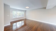 This well-appointed 1-bedroom, 1-bathroom residence at 61 Southbrook Dr in Eatontown, NJ offers a thoughtfully designed single-floor layout. Rich, polished hardwood floors flow throughout the living, dining, and bedroom areas, lending warmth and continuity to the space. The open living and dining area is bright and airy, illuminated by recessed ceiling lighting and a sliding glass door fitted with vertical blinds that opens to an outdoor view of the community. The kitchen is a standout, featuring dark espresso cabinetry, white quartz countertops, a classic subway tile backsplash, and a full suite of stainless steel appliances including a gas range, built-in microwave, dishwasher, and refrigerator. Light-toned tile flooring grounds the kitchen's modern aesthetic. The spacious primary bedroom includes a built-in closet with bifold doors and a window that fills the room with natural light. The bathroom is elegantly finished with a dark wood vanity, white quartz countertop, and marble-style tile accent wall, complemented by a mirrored medicine cabinet. Two hallways connect the rooms efficiently, completing this clean and functional layout.