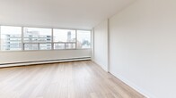 Located at 484 Avenue Rd in Toronto's prestigious Avenue Road corridor, this bright three-bedroom, one-bathroom unit offers a well-designed single-floor layout. The interior is finished with light wood flooring throughout the living and bedroom areas, complemented by crisp white walls that enhance the sense of openness. Large floor-to-ceiling windows in the bedrooms flood the space with natural light and frame sweeping views of the Toronto skyline, including the surrounding midtown cityscape.

The generously sized primary bedroom features mirrored sliding closet doors that add depth and reflect the natural light. Additional bedrooms are equally well-appointed, each with mirrored closets and access to natural light. The hallways connect the rooms efficiently, contributing to a functional and practical layout.

The kitchen is finished with white cabinetry accented by brushed gold hardware, a white rectangular tile backsplash, light quartz countertops, and a distinctive gold undermount sink — a refined touch that elevates the overall aesthetic. The bathroom continues the upscale feel with large-format marble-effect wall tiles surrounding the tub and shower area. Light porcelain tile flooring and a pedestal sink complete the clean, modern look throughout this well-appointed Toronto residence.