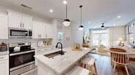 Located at 9000 Palm Passage Loop in Summerville, SC, this well-appointed single-story home offers three bedrooms, two bathrooms, and a thoughtfully designed open-concept floor plan. Light wood-look flooring flows throughout, complementing a neutral color palette that creates a bright, cohesive feel.

The kitchen is a standout feature, boasting white shaker cabinetry with matte black hardware, a classic subway tile backsplash, stainless steel appliances, and a generous granite-topped island with pendant lighting and bar seating — seamlessly connecting to the combined dining area. A dedicated workspace nook with built-in shelving adds functional versatility.

The living room is filled with natural light, highlighted by French doors that open to the outdoors, recessed lighting, and a ceiling fan. The primary bedroom is a comfortable retreat with ample natural light and access to a well-sized walk-in closet featuring multi-tier wire shelving. The bathrooms are tastefully finished with granite vanities, white cabinetry, matte black fixtures, and wood-look flooring; one includes a spacious walk-in shower with a sliding glass door and built-in shelving. Every detail of this home reflects a clean, modern aesthetic with warm, inviting touches throughout.