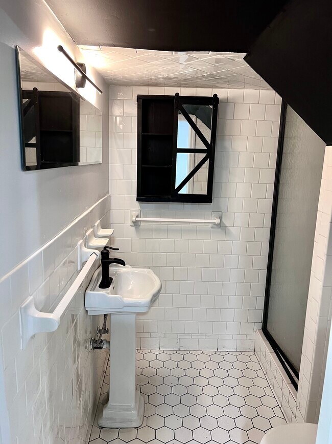 designer tile & wall lighting with a pedestal sink incorporating a black & white geometric theme. - 3367 Lake Valley Rd NW