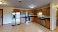 Located at 210 Briargate Rd in Mankato, Minnesota, this single-floor residence offers a practical and comfortable layout designed for everyday living. The kitchen is a standout feature, outfitted with warm oak cabinetry, dark granite-style countertops, and a full suite of stainless steel appliances including a French door refrigerator with ice maker, electric range, built-in microwave, and dishwasher. Light tile flooring and a textured ceiling complete the functional space.

The bedrooms are carpeted and finished with neutral warm tones, wood baseboards, and sliding windows that invite natural light and views of the surrounding neighborhood. The layout, as seen in the dollhouse view, includes multiple private rooms arranged efficiently off a central corridor.

Two full bathrooms serve the unit. One features a sliding glass door shower enclosure, a wood-trimmed vanity, and tile flooring. The second offers a full soaking tub and shower combination with clean white surround panels, also finished with tile flooring. Both bathrooms maintain a consistent neutral color palette with warm wood accents throughout. The overall design is straightforward and functional, providing a solid foundation for comfortable residential living in Mankato.