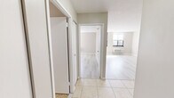 Located at 360 Main Street in Hartford, CT, this one-bedroom, one-bathroom unit offers a thoughtfully designed layout across a single floor. Light wood-tone flooring flows throughout the living and sleeping areas, complemented by neutral warm-gray walls that create a clean, cohesive aesthetic.

The living room is a generously proportioned space bathed in natural light from large floor-to-ceiling windows fitted with blinds. A wall-mounted PTAC unit provides climate control, while the open sightlines make the room feel bright and airy.

The kitchen is a standout feature, showcasing warm honey-toned cabinetry, dark granite countertops, and a peninsula with matching granite — ideal for additional prep space or casual dining. Stainless steel appliances, including a refrigerator, range, microwave, and dishwasher, complete the well-equipped cooking space. Tile flooring grounds the kitchen area seamlessly.

The bedroom offers a comfortable footprint with its own natural light source and includes a built-in closet with bi-fold doors. Additional storage is provided by three closets accessible from the hallway, offering exceptional organization throughout.

The bathroom features a clean, modern design with a floating vanity, framed mirror, lighted vanity bar, and a full tub-shower combination. Mosaic tile flooring adds a subtle decorative touch to the otherwise crisp, white space.