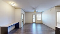 Located at 15405 Long Vista Dr in Austin, TX, this single-floor, two-bedroom, two-bathroom residence offers a well-organized and functional layout. The open living area features dark hardwood-style flooring, crown molding, a ceiling fan with light fixture, and a glass-paned entry door flanked by windows that allow natural light to fill the space. A built-in desk or utility ledge adds a practical touch near the living area entrance.

The kitchen is appointed with rich dark espresso cabinetry, light countertops, a tiled mosaic backsplash, and stainless steel appliances including a refrigerator and dishwasher, providing a sleek, modern aesthetic. Hardwood-style flooring continues throughout.

The primary bedroom is a comfortable, well-proportioned room with elevated ceilings, a ceiling fan, natural light from a window with blinds, and direct access to a dedicated closet. Its en-suite bathroom features a glass-enclosed walk-in shower with tile surround, dark vanity cabinetry, and a wall-mounted storage cabinet.

The second bedroom also includes a ceiling fan, a window for natural light, closet access, and connects to a second bathroom outfitted with a tiled shower-tub combination accented by a decorative mosaic tile border. Both bedrooms include dedicated closets with built-in shelving and hanging rods for ample storage.