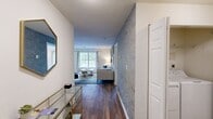 Located at One Avalon Drive in Peabody, Massachusetts, this well-appointed 2-bedroom, 2-bathroom residence offers a thoughtfully designed single-floor layout that balances comfort and style. Warm hardwood-style flooring flows consistently throughout the home, creating a cohesive and inviting atmosphere.

The living room serves as a central gathering space, highlighted by a striking exposed brick accent wall that adds texture and character. Large windows invite an abundance of natural light and provide pleasant views of the surrounding greenery.

The kitchen is outfitted with crisp white shaker cabinetry, stone countertops, a classic subway tile backsplash, and stainless steel appliances — offering both functionality and clean, modern aesthetics. Adjacent to the kitchen, the bright dining area is surrounded by oversized windows framing peaceful outdoor views of mature trees and landscaping, making it an ideal spot for everyday meals or entertaining.

The primary bedroom is generously sized, featuring large windows with garden views and easy access to a dedicated bathroom. The second bedroom is equally comfortable and well-lit. Both bathrooms are finished with clean, classic tile work, including a tiled tub-shower combination. A private balcony accessible from the unit rounds out this residence with a serene outdoor retreat overlooking lush, landscaped grounds.