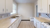 Located at 607 Robinson Ave in Syracuse, NY, this two-bedroom, one-bathroom unit offers a practical and straightforward layout across a single floor. Warm hardwood flooring runs throughout the living areas and bedrooms, lending a classic character to the space. The living room is bright and welcoming, featuring two windows that invite natural light and a radiator for heating, with direct access to the rest of the unit. The galley-style kitchen is efficiently organized with white cabinetry extending to the ceiling for ample storage, light-colored countertops, a gas range, a full-size refrigerator, and a dedicated sink area with additional cabinet space. A window above the sink area brings in natural light. Both bedrooms are comfortably sized, each featuring hardwood floors, neutral gray walls, and radiator heating. The primary bedroom benefits from two windows offering outdoor views, while the second bedroom includes a closet with its own door. The full bathroom is clean and functional, featuring a combination tub and shower with a window for ventilation. A hallway connects the rooms, and two closets provide convenient storage throughout the unit.