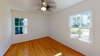 Unit #9 at 5275 Monroe in San Diego is a single-story residence featuring warm hardwood flooring that extends consistently throughout the living areas and bedrooms, lending a cohesive and inviting feel to the space. The layout includes a well-proportioned living area illuminated by natural light filtering through windows, with ceiling fans providing added comfort. A barn-style sliding door adds a stylish architectural detail to the interior.

The kitchen has been thoughtfully updated with white shaker cabinetry, a decorative patterned tile backsplash, light countertops, and stainless steel appliances including a refrigerator, dishwasher, and gas range. Light tile flooring completes the clean, functional aesthetic of this space.

The bedroom features two windows that bring in generous natural light and outdoor views of greenery, along with a ceiling fan overhead. An additional room offers a compact, versatile space with a pendant light fixture.

The bathroom is finished with a patterned mosaic tile floor, white subway-tiled tub and shower surround, a white vanity, and matte black fixtures. A window provides natural ventilation and light. Throughout the unit, crisp white walls and consistent finishes contribute to a bright, well-maintained ambiance.
