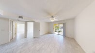 Located at 5500 NW 61st St in Coconut Creek, FL, this single-story 2-bedroom, 2-bathroom home offers a bright and functional layout finished with light-toned tile flooring throughout. The open living area features a ceiling fan with light fixture, a textured ceiling, and a sliding glass door that fills the space with natural light and provides direct access to an outdoor patio. A second entry door adds convenience and connectivity to the layout.

The kitchen is well-appointed with rich dark wood cabinetry, granite countertops, stainless steel appliances including a refrigerator, range, and built-in microwave, plus a sink with ample counter space — all set beneath a tray ceiling detail.

The spacious primary bedroom benefits from dual windows that invite abundant natural light, a ceiling fan, and direct access to an en-suite bathroom featuring a granite-topped dark wood vanity and a dedicated walk-in closet with built-in wire shelving. The second bedroom also includes a ceiling fan and a large window with outdoor views. Both bathrooms are finished with tile flooring, dark wood vanities with granite countertops, and tiled tub-shower combinations with decorative tile accents.