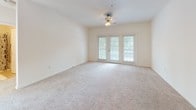 Located at 100 Excaliber Circle in Fredericksburg, Virginia, this single-floor residence offers a functional and comfortable layout designed for everyday living. The open living area is finished with neutral-toned carpet and connects directly to the entry foyer, creating an inviting and cohesive flow throughout the space. French doors in the living area introduce abundant natural light and provide outdoor access, complemented by a ceiling fan overhead. The kitchen is well-appointed with light maple cabinetry, dark granite-style countertops, tile flooring, and black appliances including a range and dishwasher, along with ample counter and storage space.

The bedrooms are carpeted and bright, each featuring double windows with blinds that allow natural light to fill the rooms. The bathrooms include tile flooring and warm wood vanity cabinetry; one bathroom features a tub-shower combination, while a second bathroom includes a shower with a decorative curtain. A dedicated laundry area accommodates a full-size washer and dryer, adding practical convenience. Throughout the home, neutral wall tones and consistent finishes create a clean, cohesive aesthetic suited to a variety of styles.