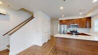 Located at 92 Plains Rd in Milford, Connecticut, this two-story residence combines modern design with functional living across two well-organized floors. The main level features an open-concept layout where the living area flows seamlessly into the kitchen. The kitchen is thoughtfully equipped with rich warm-toned cabinetry, white quartz countertops, stainless steel appliances including a refrigerator, range, and microwave, and a central island with an integrated sink — ideal for both cooking and casual dining. Hardwood-style flooring runs throughout the main level, complementing the bright, recessed lighting overhead. A half bath is conveniently located on the first floor. A staircase with a wood railing connects the floors. Upstairs, the second floor features rooms with charming vaulted ceilings and multiple windows that invite natural light and neighborhood views. The upper-level full bathroom is finished with light marble-look tile flooring, a wood-toned vanity with a white countertop, and a tub/shower combination enclosed by sliding glass doors. A wall-mounted mini-split unit provides efficient climate control. The overall aesthetic throughout is clean, contemporary, and move-in ready, with consistent finishes tying the space together cohesively.
