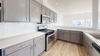 Located in Seattle's vibrant Capitol Hill neighborhood, this three-bedroom, two-bathroom residence offers a thoughtfully designed single-floor layout with a bright, contemporary feel. Light hardwood flooring flows throughout the open-concept living, dining, and kitchen area, which is bathed in natural light from large windows that frame views of the surrounding Seattle skyline. The living area connects seamlessly to a private balcony, extending the livable space outdoors.

The kitchen is well-appointed with gray shaker-style cabinetry, white quartz countertops, a classic subway tile backsplash, and a full suite of stainless steel appliances including a gas range, built-in microwave, and refrigerator. A dedicated hallway leads to the three bedrooms, each carpeted for comfort. The bedrooms feature closets and clean white walls, with select rooms offering city views through wide windows. The primary bathroom includes a glass-enclosed walk-in shower and a vanity with quartz countertops, while the second bathroom features a full soaking tub and shower combo. Additional conveniences include an in-unit laundry area and multiple closets throughout the home, rounding out a functional and modern urban residence.