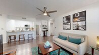 Located at 211 S Old Coachman Rd in Clearwater, Florida, this well-appointed one-bedroom, one-bathroom unit offers a thoughtfully designed single-floor layout. Wood-style plank flooring flows throughout the space, lending a cohesive and contemporary feel from the moment you enter.

The open-concept living and kitchen area serves as the heart of the home. The living room is bathed in natural light from large windows dressed with sheer curtains and blinds, and is topped by a modern ceiling fan with an integrated light fixture. The kitchen features crisp white cabinetry, stainless steel appliances including a full-size refrigerator and microwave, and a breakfast bar with seating—ideal for casual dining.

The bedroom is a comfortable, well-lit retreat with its own ceiling fan, a large window with outdoor views, and direct access to a dedicated walk-in closet. The clean, white bathroom includes a tub-shower combination, a single-sink vanity with light countertops, white cabinetry, and a large mirror.

A dedicated laundry room with a full-size washer and dryer adds everyday convenience. Two closets provide ample storage throughout. The textured ceilings and bright white walls create a clean, airy ambiance that carries through every room of this functional Clearwater residence.