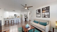 Located at 211 S Old Coachman Rd in Clearwater, Florida, this well-appointed one-bedroom, one-bathroom unit offers a thoughtfully designed single-floor layout. Wood-style plank flooring flows throughout the space, lending a cohesive and contemporary feel from the moment you enter.

The open-concept living and kitchen area serves as the heart of the home. The living room is bathed in natural light from large windows dressed with sheer curtains and blinds, and is topped by a modern ceiling fan with an integrated light fixture. The kitchen features crisp white cabinetry, stainless steel appliances including a full-size refrigerator and microwave, and a breakfast bar with seating—ideal for casual dining.

The bedroom is a comfortable, well-lit retreat with its own ceiling fan, a large window with outdoor views, and direct access to a dedicated walk-in closet. The clean, white bathroom includes a tub-shower combination, a single-sink vanity with light countertops, white cabinetry, and a large mirror.

A dedicated laundry room with a full-size washer and dryer adds everyday convenience. Two closets provide ample storage throughout. The textured ceilings and bright white walls create a clean, airy ambiance that carries through every room of this functional Clearwater residence.