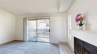 This single-floor residence offers a practical and comfortable layout across two bedrooms and three bathrooms. The living room serves as the heart of the home, featuring a classic fireplace with a white tile surround and mantel, plush carpet flooring, and a sliding glass door that opens to a private balcony with exterior views—allowing generous natural light to fill the space. An additional side window further brightens the area.

The kitchen is efficiently designed with white cabinetry, light granite-style countertops, a peninsula breakfast bar, and light hardwood-style flooring, creating a clean and cohesive aesthetic. It flows naturally into the main living area, making it ideal for everyday use and entertaining.

Both bedrooms are carpeted and well-lit, each featuring large windows with vertical blinds that invite natural light. The spacious primary bedroom includes its own sliding glass door access to a balcony. The bathrooms are neatly finished, with one featuring a dual-sink vanity with white cabinetry, a large mirror, and hardwood-style flooring. The additional bathrooms include a clean tub-shower combination. Textured ceilings and neutral wall tones are consistent throughout, giving the entire residence a bright, cohesive feel.