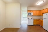 Located at 630 Water St in Santa Cruz, California, this efficient one-bedroom, one-bathroom unit offers a well-organized single-floor layout designed to maximize every square foot. The open-concept design connects the kitchen directly to the living area, creating a seamless flow throughout the space. Warm neutral walls and consistent hardwood-style flooring run throughout, lending the unit a cohesive and inviting feel.

The kitchen is thoughtfully equipped with honey-toned wood cabinetry spanning both upper and lower configurations, a stainless steel sink, a coil-top electric range, an over-the-range microwave, and a full-size refrigerator — providing all essential cooking amenities in a compact footprint. Light countertops complement the cabinetry and contribute to a clean, functional workspace.

The living area opens toward a sliding glass door that leads to a private balcony, allowing natural light to fill the space and offering a pleasant outdoor connection. The bedroom features the same hardwood-style flooring, clean white walls, and ample vertical space, providing a quiet and functional retreat. The bathroom includes a vanity with wood cabinetry, a toilet, and a grab bar, finished with the same consistent flooring found throughout the unit. Overall, this space offers practical, comfortable living in a well-maintained setting in the heart of Santa Cruz.