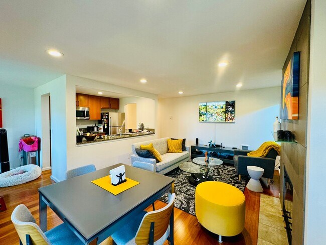 Bright and stylish open-concept living space with cozy seating, modern lighting, & wood flooring - 2145 Dexter Ave N