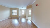 Located at 100 Holling FR in Frederick, Maryland, this single-floor residence offers a thoughtfully designed layout that balances functionality and style. The open-concept living and dining area is bathed in natural light from multiple windows fitted with blinds, and features warm-toned walls, crown molding, and gleaming hardwood-style flooring that extends throughout the main living spaces.

The kitchen is a standout feature, showcasing rich dark espresso cabinetry that extends to the ceiling for ample storage, light granite countertops, a classic white subway tile backsplash, and a full suite of stainless steel appliances including a gas range, built-in microwave, and refrigerator. A peninsula with granite countertop provides additional prep space and casual seating, while pendant lighting adds a refined touch overhead.

The bedrooms offer plush wall-to-wall carpeting, warm neutral walls, and windows that allow for natural light, creating a comfortable and restful atmosphere. The bathroom is finished with a dark wood vanity, white countertop, a well-lit mirror, and a tiled tub-shower combination, reflecting the same quality of finishes seen throughout the home. Crown molding and consistent warm tones lend the entire space a cohesive and polished character.
