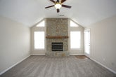This single-story home offers a well-designed, functional layout with a variety of thoughtful features throughout. The living room serves as the focal point of the home, boasting vaulted ceilings, a striking floor-to-ceiling stacked stone fireplace with a wood mantle, and abundant natural light from multiple windows. A ceiling fan adds comfort to the generous open space, which flows into the rest of the home via wood-look flooring.

The kitchen is equipped with white cabinetry, dark countertops, and white appliances including a range, built-in microwave, and refrigerator, all set on warm hardwood-style flooring. The spacious bedrooms feature plush carpet, ceiling fans with light fixtures, and windows that bring in natural light with views of the surrounding neighborhood.

The primary bathroom is a standout, offering a large corner jetted soaking tub, a separate walk-in shower, warm hardwood-style flooring, and a wide mirrored vanity area. Additional bathrooms feature tub-shower combinations, white vanities, and the same warm wood flooring. Throughout the home, neutral warm-toned walls, white trim, and textured ceilings create a cohesive and inviting atmosphere.