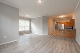 Located at Grand Island in Memphis, TN, this single-floor unit offers a well-designed layout with a cohesive, neutral aesthetic throughout. The kitchen is a standout feature, equipped with warm honey-toned cabinetry, stainless steel appliances including a range, refrigerator, and dishwasher, complemented by a classic white subway tile backsplash and a peninsula with a double sink — ideal for both cooking and casual dining. Light wood-look flooring extends through the main living and kitchen areas, adding warmth and continuity. Living spaces are bathed in natural light through sizable windows fitted with horizontal blinds, and crown molding adds a refined architectural detail. The bedrooms are carpeted for comfort, each featuring ceiling fans and ample natural light. One bedroom offers notably generous proportions with a walk-in closet outfitted with multi-level wire shelving for organized storage. The bathroom is clean and functional, featuring a vanity with wood cabinetry, a grey countertop, a large mirror, and a tub-shower combination. A dedicated laundry area with side-by-side washer and dryer connections and built-in shelving above adds everyday convenience. Throughout the unit, grey interior doors and neutral wall tones create a cohesive, move-in-ready environment.