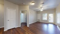 Located at 1010 Locke St in San Antonio, TX, this single-story residence offers a well-designed open-concept layout that connects the living, dining, and kitchen areas into one cohesive, flowing space. Rich, dark hardwood-style flooring runs throughout the main living areas and bedrooms, creating a warm and cohesive aesthetic. Ceiling fans are installed throughout, providing both comfort and a finished look to each room.

The kitchen is equipped with dark espresso cabinetry, light countertops, white appliances including a range, microwave, refrigerator, and dishwasher, and features a peninsula that opens to the main living area. A dedicated pantry offers generous storage space. Natural light enters through multiple windows, giving the space a bright and welcoming feel.

The bedrooms are generously sized, each featuring ceiling fans, hardwood-style flooring, and individual closets with built-in shelving. The primary bedroom connects to a private bathroom featuring dark wood cabinetry, a dual-sink vanity, and a soaking tub. A secondary bathroom with tile flooring and accessibility grab bars provides added functionality. The unit also includes a walk-in pantry or storage closet visible from the kitchen area, rounding out this practical and comfortable single-floor home.