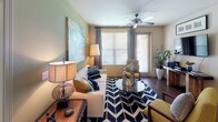 Located at 6608 S West Shore Blvd in Tampa, FL, this single-floor residence offers a well-designed layout with contemporary finishes throughout. The kitchen is outfitted with dark espresso cabinetry, stainless steel appliances including a refrigerator, range, and microwave, and rich hardwood-style flooring. A curved granite breakfast bar with seating connects the kitchen to the living and dining area, creating an open, functional flow ideal for entertaining. The living room features ceiling fans, warm neutral tones, and a sliding glass door that opens to a private balcony, filling the space with natural light. The bedrooms are carpeted and well-proportioned, each equipped with ceiling fans and windows that let in ample light. One bedroom features a walk-in closet with built-in wire shelving, providing generous storage. The bathrooms are finished with granite countertops, dark cabinetry, and tile flooring. The primary bathroom includes an elongated vanity, a walk-in shower with glass enclosure, and direct access to a spacious walk-in closet. Additional closet and storage space is found throughout. The overall ambiance is modern and cohesive, with consistent dark cabinetry and granite finishes tying the home together.