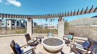 This well-appointed single-floor residence offers a thoughtfully designed open-concept layout that seamlessly connects the main living areas. The kitchen is a standout feature, showcasing rich dark espresso cabinetry, stainless steel appliances including a French door refrigerator and gas range, white quartz countertops, and a tile backsplash — all complemented by warm wood-look flooring that flows throughout the common areas. A kitchen island provides additional prep space and serves as a natural transition into the living area. The living room is bright and inviting, featuring a ceiling fan, large windows dressed with sheer curtains and blinds, and access to an exterior door that allows natural light to fill the space. Contemporary abstract artwork adorns the neutral-toned walls, enhancing the modern aesthetic. The bedroom is a serene retreat with plush carpeting, a ceiling fan, ample natural light from a large window, and direct access to a walk-in closet with built-in shelving. The bathroom is finished with large-format white tile flooring, a soaking tub with shower, a toilet, and dark wood upper cabinetry, offering a clean and functional design. Recessed lighting throughout ensures a well-lit environment across all areas of the home.