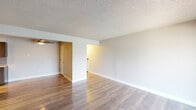 This single-floor residential unit offers a thoughtfully laid-out living space designed for comfort and functionality. The open living area features light hardwood-style flooring and a textured ceiling, creating a bright and welcoming atmosphere. Sliding glass doors lead to a private balcony, flooding the room with natural light and offering pleasant outdoor views.

The kitchen is well-equipped with rich dark cabinetry, granite-look countertops, a stylish hexagonal tile backsplash, stainless steel appliances, and track lighting overhead — combining a modern aesthetic with practical design.

The bedrooms are generously sized and finished with plush carpeting, offering a quiet and comfortable retreat. Windows with blinds allow for natural light while maintaining privacy. One bedroom features direct access to a bathroom and a walk-in closet, adding to its functionality.

The bathrooms are clean and well-appointed. One features a tub-shower combination with white subway tile surround accented by a mosaic tile detail strip and brushed nickel fixtures. A second bathroom offers a functional tiled shower with a classic design.

Throughout the unit, neutral tones, clean white trim, and consistent flooring choices create a cohesive and move-in-ready environment that is both practical and inviting.