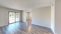 This well-appointed 2-bedroom, 2-bathroom single-floor residence in Lincolnton, NC offers a practical and comfortable layout designed for everyday living. The living room serves as the heart of the home, featuring durable wood-style laminate flooring, neutral beige tones, and a sliding glass door that opens to a private balcony, filling the space with natural light. Adjacent to the living area, the kitchen is outfitted with crisp white shaker-style cabinetry, white countertops, and a full suite of stainless steel appliances including a refrigerator, dishwasher, and electric range. Wood-style flooring continues throughout, complementing the clean, modern aesthetic. Both bedrooms are carpeted for comfort and feature textured ceilings, sliding or bi-fold closet doors, and windows that allow in natural light. The primary bedroom offers a generous footprint with ample closet storage. The two bathrooms are finished with white vanities, white countertops, and chrome fixtures; one includes a full tub-shower combination. Neutral wall tones and consistent finishes throughout the home create a cohesive and inviting atmosphere, making this residence a functional and move-in-ready space in Colonial Village.