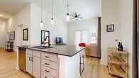 Located in Denton, TX, this single-story 3-bedroom, 3-bathroom home offers a thoughtfully designed open-concept layout with modern finishes throughout. The kitchen is a standout feature, equipped with gray shaker cabinets, dark granite countertops, a subway tile backsplash, stainless steel appliances, and a peninsula island with bar seating — all flowing seamlessly into the dining and living areas. Soaring ceilings amplify the sense of space across the main living areas, which are finished with light wood-style flooring. The living room benefits from generous natural light through large windows and French doors. A dedicated dining area provides an intimate space just off the main living zone. The primary bedroom is generously sized with plush carpeting and a private bathroom featuring a granite-topped vanity with gray cabinetry. Additional bedrooms also offer carpeted flooring and easy access to their respective bathrooms, each finished with matching granite countertops. A dedicated laundry room houses full-size washer and dryer units with built-in shelving. Spacious closets offer ample storage. The home's clean, neutral palette and consistent design language create a bright, cohesive, and functional living environment.