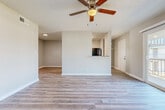 This 2-bedroom, 1-bathroom residence is laid out on a single floor, offering a well-organized and functional living environment. The living room features light-toned wood-look flooring, neutral gray walls, and a ceiling fan with integrated lighting, creating a clean, comfortable gathering space. Adjacent to the living area, the galley-style kitchen is equipped with white cabinetry, granite-style countertops, a subway tile backsplash, and black appliances including a refrigerator, electric range, and dishwasher. Light wood-look flooring continues throughout the kitchen, which also provides direct access to an exterior door.

Both bedrooms are carpeted and feature ceiling fans, neutral-toned walls, and windows that allow natural light to filter in. The primary bedroom is notably spacious, offering two separate doorways leading to a dedicated closet and direct access to the shared bathroom. The second bedroom also includes its own closet for additional storage. The full bathroom is finished with a white vanity, mirror, overhead lighting, and a tiled shower-tub combination. Textured ceilings are consistent throughout the residence, contributing to its cohesive, understated aesthetic.