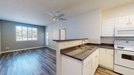 This single-story residence at 650 Woodward Street in San Marcos, California offers a well-designed, functional layout with clean, modern finishes throughout. The open-concept living and kitchen area is anchored by wood-look plank flooring, neutral-toned walls, and a ceiling fan that promotes comfortable airflow. The kitchen features white cabinetry with dark countertops, a peninsula with a double sink, and white appliances including a refrigerator, electric range, and over-the-range microwave — providing both practicality and a cohesive aesthetic.

The bedrooms are carpeted for comfort, each with natural light supplied by windows fitted with blinds, and ceiling fans for added ventilation. The rooms offer a neutral palette that lends itself to versatile use. A dedicated living area with wood-look flooring and a window provides a bright, airy feel.

The unit includes two bathrooms: a full bath with a tub/shower combination, grab bar, white vanity, and dark countertop, and a half bath with a single-sink vanity, large mirror, and matching finishes. Both bathrooms continue the wood-look flooring seen throughout the common areas. Overall, the space presents a clean, move-in-ready environment with consistent finishes and a practical floor plan suited for everyday living.