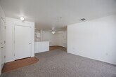 Located at 750 South 15th Avenue in Yuma, Arizona, this single-floor residence offers a practical and well-organized layout with three bedrooms, three bathrooms, and a thoughtfully arranged set of living spaces. The living room is carpeted and bright, featuring a sliding glass door fitted with vertical blinds that opens to a private balcony, allowing for natural light and outdoor access. The combined dining and kitchen area is a functional galley-style space with wood-look flooring, white cabinetry, a coil electric range, a dishwasher, and a double sink — all set beneath overhead lighting that keeps the area bright and clean. A ceiling fan is present in the adjoining dining zone, adding comfort to the space. The three bedrooms are carpeted and neutrally finished, each offering a calm and versatile environment. The primary bedroom is a comfortable size and is accompanied by a spacious walk-in closet outfitted with wire shelving racks for organized storage. Altogether, the residence includes eight closets, ensuring abundant storage options throughout. The three bathrooms each feature wood-look flooring, tub/shower combinations with tiled surrounds, and clean white vanities with built-in cabinetry. The overall aesthetic is clean and neutral throughout, providing a move-in ready canvas.