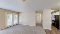 Located at 6300 Moseley Dixon Rd in Macon, GA, this single-floor, 2-bedroom, 2-bathroom home offers a well-organized layout with comfortable, functional living spaces throughout. The kitchen is outfitted with crisp white cabinetry, granite-style countertops, a dishwasher, and wood-look flooring, providing a clean and modern workspace. The combined kitchen and living room area flows naturally, with the living room featuring plush carpeting and French doors that open onto a private outdoor deck overlooking a lush, tree-lined backdrop — an inviting spot to enjoy the natural surroundings. Both bedrooms are carpeted and equipped with ceiling fans and windows that bring in natural light. The generously sized primary bedroom includes a dedicated closet with bifold doors and built-in shelving for organized storage. The two bathrooms each feature a full tub-and-shower combo, with one bathroom showcasing a white vanity with granite countertop and wood-look flooring. A hallway closet provides additional storage. Neutral warm-beige tones throughout the home create a calm, cohesive ambiance, while clean white trim and doors add a crisp finish. The outdoor deck offers serene wooded views, enhancing the overall appeal of this practical and comfortable Macon home.