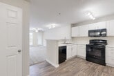 Located at 3636 Belmont St in Greensboro, NC, this one-bedroom, one-bathroom residence offers a well-organized single-floor layout designed for comfortable everyday living. The open-concept kitchen and living area forms the heart of the home, where durable hardwood-style flooring flows throughout. The kitchen is equipped with crisp white cabinetry, light stone-look countertops, a tile backsplash, and black GE appliances including an electric range, over-the-range microwave, and dishwasher. A peninsula with a sink provides additional prep space and a natural transition into the living area, which features a ceiling fan and access to natural light through a glass-paneled door. The generously sized primary bedroom is carpeted for comfort, fitted with a ceiling fan, and includes a window overlooking the surrounding greenery. A dedicated closet provides organized storage, while a separate laundry closet houses a full-size GE washer and dryer. The bathroom features hardwood-style flooring, a bathtub/shower combination, and clean neutral tones throughout. Neutral wall colors and consistent finishes create a cohesive, move-in-ready ambiance throughout the entire residence.