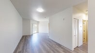 Located on Tanglewood Drive in Richland, Washington, this 2-bedroom, 3-bathroom residence offers a well-organized, single-floor layout designed for comfortable everyday living. The open-concept living room and kitchen area serves as the heart of the home, bathed in natural light from a sliding glass door that leads to the outdoors. The living space features smooth, neutral-toned LVP flooring that extends throughout the main areas, creating a clean and cohesive aesthetic. The kitchen is outfitted with gray two-tone cabinetry, white countertops, a black matte faucet, and white appliances including a dishwasher, electric range, and range hood—all set atop matching LVP flooring for a seamless transition from living to cooking spaces. The primary bedroom is generously proportioned, complete with plush wall-to-wall carpeting and access to a dedicated walk-in closet featuring a full hanging rod and built-in shelf. The second bedroom is equally well-appointed with soft carpeting and ample wall space. Three bathrooms serve the unit, including one with a full tub-shower combination finished in crisp white. Light wood-toned interior doors and trim add warmth throughout, while the crisp white walls maintain a bright, airy atmosphere across the entire residence.