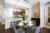 Located at 4285 Johns Creek Pkwy in Suwanee, Georgia, this single-floor residence offers a thoughtfully designed layout that balances comfort and functionality. The open-concept kitchen serves as a central hub, showcasing rich wood cabinetry, granite countertops, a tile backsplash, and a full suite of stainless steel appliances. A curved breakfast bar with pendant lighting provides casual seating and flows naturally toward the entryway, which features warm hardwood flooring throughout the main living areas. The living room is bright and welcoming, with large windows dressed in layered curtains, crown molding, and a ceiling fan that contribute to an airy, polished ambiance. Multiple bedrooms offer plush carpeting, generous natural light from well-placed windows, and ample space for furnishings. The primary bedroom suite is complemented by a spacious en-suite bathroom featuring a dual-sink vanity with granite countertops, tile flooring, a glass-enclosed shower, and direct access to a walk-in closet. A second full bathroom includes a tub-shower combination and its own walk-in closet access. The neutral color palette and cohesive design elements throughout create a harmonious, move-in-ready environment suited for everyday living.