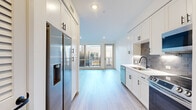 Located at 1070 W Hampden Ave in Englewood, Colorado, this thoughtfully designed single-floor studio offers a clean, modern aesthetic with an efficient and well-appointed layout. Light wood-tone flooring runs continuously throughout, lending warmth and visual cohesion to the entire space.

The kitchen is a standout feature, outfitted with crisp white shaker cabinetry accented by matte black hardware, a textured tile backsplash, and light quartz countertops. Stainless steel appliances — including a French door refrigerator with ice maker, a slide-in range, built-in microwave, and dishwasher — provide a fully equipped culinary space. Under-cabinet lighting adds both function and ambiance.

The kitchen flows seamlessly into the open living area, which is bathed in natural light from large floor-to-ceiling windows. A sliding glass door connects the living space to a private outdoor balcony, offering views of the surrounding neighborhood. The entry area includes a louvered closet door for convenient storage access.

The bathroom features a soaking tub with a full-height large-format tile surround and matte black fixtures, delivering a clean, spa-inspired finish. Together, these spaces create a cohesive, modern living environment ideal for those seeking a well-designed and efficiently planned home in the Denver metro area.