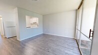 Located at 4609 Broadmoor Dr in Meridian, Mississippi, this single-story, one-bedroom, one-bathroom unit offers a clean and functional layout designed for comfortable everyday living. Throughout the unit, light-toned vinyl plank flooring provides a cohesive and modern aesthetic, complemented by neutral gray-white walls and crisp white trim.

The combined living and dining area serves as the heart of the home, highlighted by a large sliding glass door that floods the space with natural light and opens to a view of a grassy outdoor area. A pass-through window connects the living space directly to the kitchen, enhancing the open feel. The kitchen is efficiently laid out in a galley style, featuring white cabinetry, white countertops, and white appliances including an electric range and refrigerator.

The generously sized primary bedroom includes a built-in vanity desk area, a closet with louvered doors, and a window that brings in additional natural light. A hallway connects the main living spaces to the full bathroom, which includes a tiled tub-shower combination. The unit also features an additional unclassified room, offering flexible utility space. Overall, the unit presents a bright, clean, and practical living environment.