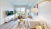 Located along Island Highway North in Nanaimo, BC, this well-appointed one-bedroom, one-bathroom unit offers a thoughtfully designed single-floor layout with modern finishes throughout. Light wood-look flooring flows seamlessly across all rooms, complementing the bright, neutral palette that defines the space.

The open-concept kitchen is a standout feature, showcasing high-gloss white cabinetry, subway tile backsplash, gray quartz countertops, stainless steel appliances including a gas range and refrigerator, and a functional island — ideal for both cooking and casual dining.

The living room is bathed in natural light through large windows and features direct access to an outdoor patio area, offering pleasant views of the surrounding greenery and neighboring buildings. The space is comfortable and well-proportioned, flowing naturally into the dining and kitchen areas.

The bedroom is a serene retreat with a large window framing outdoor views, providing ample natural light. It offers a quiet, restful atmosphere with enough room for a full bedroom suite.

The bathroom is clean and modern, featuring wood-look flooring, a vanity with storage, and a shower-tub combination. A hallway closet with stacked in-suite laundry adds everyday convenience, rounding out this efficient and stylish Nanaimo residence.