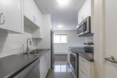 Located at 246 King St E in Clarington, Ontario, this one-bedroom, one-bathroom unit offers a thoughtfully designed layout across a single floor. The open-concept living, dining, and kitchen area forms the heart of the space, providing a functional and cohesive environment for everyday living. The kitchen is a standout feature, outfitted with white cabinetry, a subway tile backsplash, dark countertops, and a full suite of stainless steel appliances including a refrigerator, electric range, and microwave. A peninsula with counter seating adds convenience and separates the kitchen from the living and dining area. Light tile flooring runs through the kitchen, while a distinctive parquet wood floor extends through the living area and bedroom, adding warmth and character. The bedroom is a comfortable size, with a window that allows natural light to enter and offers views of the surrounding neighbourhood. A baseboard heating unit ensures year-round comfort. The bathroom is finished with clean white subway tile surrounding a full soaker tub and shower, complemented by chrome fixtures for a crisp, polished look. Neutral wall tones throughout the unit create a bright and welcoming atmosphere.