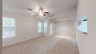 Located at 200 Crowne Club Dr in Winston-Salem, NC, this one-bedroom, one-bathroom residence offers a well-designed single-floor layout with a comfortable and functional living space. The open living area features vaulted ceilings, plush wall-to-wall carpeting, and a ceiling fan, creating an airy and inviting atmosphere. Natural light filters in through multiple windows fitted with blinds, while a track lighting fixture and a pass-through window connecting to the kitchen add practical character to the space. The kitchen is well-appointed with rich dark wood cabinetry, light stone-look countertops, black appliances including a range, microwave, and refrigerator, and wood-look vinyl flooring that adds warmth and durability. The generously sized bedroom features vaulted ceilings, a ceiling fan, multiple windows offering natural light and outdoor views, and direct access to a dedicated walk-in closet. The bathroom is finished with wood-look vinyl flooring, a tiled tub-shower combination with a decorative black tile accent border, a vanity with stone-look countertops, and brushed nickel fixtures and accessories. Throughout the residence, neutral tones and clean finishes create a cohesive and move-in-ready aesthetic.