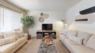 This single-floor residence offers a thoughtfully arranged layout designed for comfortable everyday living. The living room serves as the heart of the home, featuring plush carpeting, large windows that invite natural light, and ample space for both lounging and entertaining. An entry area with tile flooring transitions seamlessly into the carpeted living space.

The galley-style kitchen is well-equipped with warm honey-toned wood cabinetry, dark granite-style countertops, a double basin sink, and white appliances including a range and refrigerator. Tile flooring and a pendant light add practical charm to the space. Adjacent to the kitchen, the dining area provides room for a full dining table and includes a closet for additional storage.

The primary bedroom is a serene retreat with soft carpeting, a window for natural light, and generous room for a full bedroom suite. A secondary bedroom offers versatility with carpeted floors, a closet with open shelving, and space suited for multiple sleeping arrangements.

The full bathroom features tile flooring, a wood vanity with granite-style countertops, a large mirror, and a tub-shower combination with white tile surround. A dedicated laundry room rounds out the home, complete with a full-size washer and dryer and built-in shelving for added storage convenience.