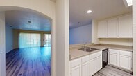 This well-appointed single-story residence in Davis offers four bedrooms and three bathrooms across a generously sized floor plan. The open-concept kitchen and living room serve as the heart of the home, connected by a charming arched passageway. The kitchen is equipped with white cabinetry, neutral countertops, a double-basin sink, a stainless steel range, a built-in microwave, and a dishwasher, with a skylight adding natural brightness overhead. A ceiling fan and large sliding glass doors in the living area flood the space with natural light and provide direct outdoor access.

Light-toned vinyl plank flooring flows consistently throughout the entire residence, lending a clean and cohesive aesthetic. The hallways feature elegant arched entryways that lend a distinctive architectural touch to the home. The spacious primary bedroom offers ample room and is complemented by a generously sized walk-in closet with built-in shelving and hanging rods. Additional bedrooms are well-proportioned with good natural light. The three bathrooms are clean and functional, each featuring tub-shower combinations and vanities. A dedicated laundry room houses a full-sized washer and dryer, adding everyday convenience to this practical and comfortable home.
