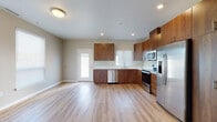 Located at 15 C St in Independence, Oregon, this two-story residence offers a well-designed layout with functional living spaces spread across both levels. The main floor features an open-concept living and kitchen area finished with light hardwood-style flooring that enhances the sense of spaciousness. The kitchen is a standout feature, outfitted with rich, dark walnut-toned cabinetry extending to the ceiling, white countertops, and a full suite of stainless steel appliances including a refrigerator with ice maker, range, microwave, and dishwasher. Recessed lighting and a window above the sink bring natural light into the cooking space. A secondary exterior door provides convenient access from the main level. The upper floor hosts carpeted bedrooms, each benefiting from natural light through blinded windows. The bedrooms include closets with sliding doors and built-in shelving. A full bathroom on this level features a tub-shower combination, hardwood-style flooring, and a window for ventilation. A dedicated in-unit laundry area with a full-size washer and dryer adds everyday convenience. The property also includes a spacious attached garage with a concrete floor, drywall-finished walls, and interior access — ideal for secure parking or additional storage.