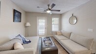 Located at 1523 Roswell Rd in Marietta, GA, this single-floor, 2-bedroom, 2-bathroom residence offers a thoughtfully designed layout that maximizes comfort and functionality. The open-concept kitchen features white cabinetry, light countertops, stainless steel appliances including a refrigerator, range, and dishwasher, and track lighting overhead. It flows seamlessly into the combined dining and living area, where wood-look flooring extends throughout the main living spaces. The dining area comfortably accommodates a full-sized table and is complemented by neutral walls and a textured ceiling. The living room benefits from natural light streaming through multiple windows and a glass exterior door, with a ceiling fan adding to the airy feel. Both bedrooms are carpeted and equipped with ceiling fans; the primary bedroom features a large window with outdoor views and access to a spacious walk-in closet with wire shelving systems. The second bedroom also offers closet storage. Each bathroom includes a tiled shower-tub combination with a classic white-and-black tile accent border. A hallway connects all rooms, lending the floor plan a practical, easy-to-navigate flow throughout the home.