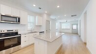 Located at 1392 E Bonds Ranch Rd in Fort Worth, TX, this single-story, 2-bedroom, 2-bathroom home offers a clean, modern aesthetic defined by bright white walls, light wood-look flooring, and abundant natural light flowing through slatted window blinds. The open-concept living area connects seamlessly to the kitchen and dining space, creating a welcoming and functional layout. The kitchen is a standout feature, showcasing white shaker-style cabinetry, granite countertops, a central island with additional counter space, and a full suite of stainless steel appliances including a refrigerator, range, microwave, and dishwasher. Recessed lighting and a ceiling fan enhance the comfort of the main living area. The primary bedroom offers generous space with dual windows and a ceiling fan, complemented by closet storage. The en-suite bathroom features a walk-in glass shower with white tile surround and built-in shelving, while the second bathroom includes a full tub-shower combo. Two additional closets and a pantry provide ample storage throughout. A hallway connects the private areas of the home, and a patio extends the living space outdoors. The home's consistent, bright palette and modern finishes create a cohesive and inviting atmosphere throughout.