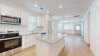 Located at 1392 E Bonds Ranch Rd in Fort Worth, TX, this single-story, 2-bedroom, 2-bathroom home offers a clean, modern aesthetic defined by bright white walls, light wood-look flooring, and abundant natural light flowing through slatted window blinds. The open-concept living area connects seamlessly to the kitchen and dining space, creating a welcoming and functional layout. The kitchen is a standout feature, showcasing white shaker-style cabinetry, granite countertops, a central island with additional counter space, and a full suite of stainless steel appliances including a refrigerator, range, microwave, and dishwasher. Recessed lighting and a ceiling fan enhance the comfort of the main living area. The primary bedroom offers generous space with dual windows and a ceiling fan, complemented by closet storage. The en-suite bathroom features a walk-in glass shower with white tile surround and built-in shelving, while the second bathroom includes a full tub-shower combo. Two additional closets and a pantry provide ample storage throughout. A hallway connects the private areas of the home, and a patio extends the living space outdoors. The home's consistent, bright palette and modern finishes create a cohesive and inviting atmosphere throughout.
