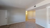 This single-floor, one-bedroom, one-bathroom residence in Beaumont, Texas offers a well-organized layout designed for comfortable everyday living. The living area features neutral-toned carpet, light gray walls, and a smooth white ceiling with overhead HVAC venting, creating a clean and move-in-ready atmosphere. A transition to wood-look flooring marks the entryway, adding a practical touch near the front door.

The kitchen is equipped with white cabinetry, dark speckled countertops, a white electric coil-burner range with overhead ventilation hood, and a dishwasher, providing all the essentials for daily meal preparation. The cabinetry offers ample storage, and the layout allows for efficient use of the cooking space.

The bedroom is generously sized, featuring plush carpet, a window with blinds that brings in natural light, and a reach-in closet with double doors for storage. The bathroom includes a full-size soaking tub with a tub/shower combination and bright white surrounds, along with a separate vanity area featuring a wide countertop with built-in drawers and a large wall mirror illuminated by overhead lighting. The overall aesthetic throughout is clean, neutral, and functional, making this unit a practical choice in the Beaumont area.